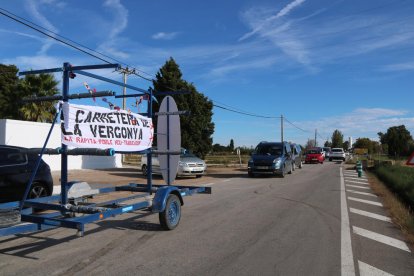 Imagen de los vehículos que han participado en la marcha lenta, que abría un remolque con una pancarta con el lema 'La carretera de la vergüenza'