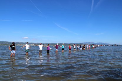 Els participants fent la cadena humana a la badia del Fangar, a l'Ampolla (Baix Ebre), per denunciar la regressió que pateix el delta de l'Ebre.