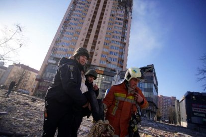 Els equips d'emergència evacuen una dona ferida en l'atac al centre de Kiev.