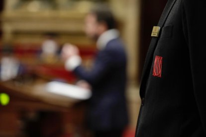 Escudo del Parlament en la solapa de la chaqueta de un trabajador de la cámara.