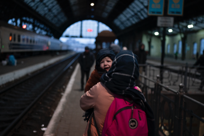 Una dona amb un infant a l'estació de tren de Lviv.