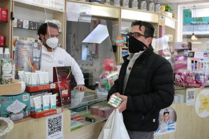 Un usuario comprando tres macetas de antígenos en una farmacia.