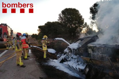 Un bomber remullant la cabina del camió.