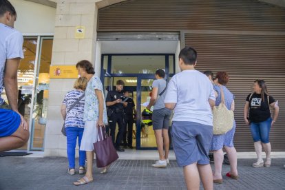 Les portes de l'Oficina de Tràmits del DNI i Passaport s'acumulen de gent que espera el seu torn per a renovar els seus documents.