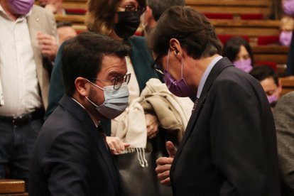 El presidente de la Generalitat, Pere Aragonès, hablando con el líder del PSC en el Parlament, Salvador Illa.