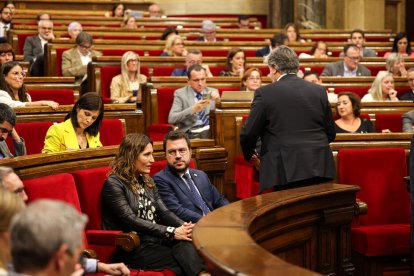 El presidente de Junts, Albert Batet, de espaldas con el presidente de la Generalitat, Pere Aragonès, sentado.