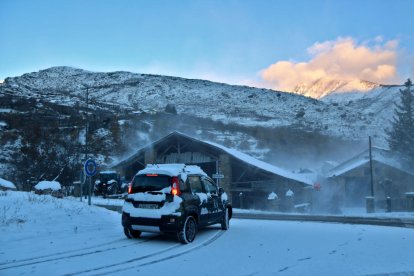 Un cotxe ple de neu circulant per una rotonda.