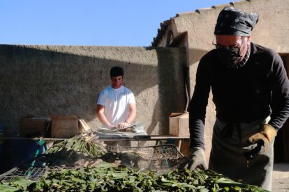 Dos treballadors del restaurant Cal Ganxo de Valls preparen els calçots per als comensals.