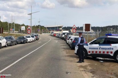 Un mosso vigilando la zona de aparcamiento de vehículos próxima a la estación de trenes del Camp de Tarragona.