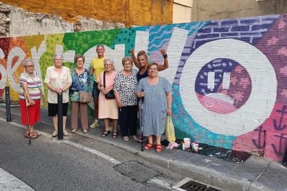 Barral (de negre) i Julbe, amb unes residents del barri davant d'un dels murals afectats pels actes vandàlics.