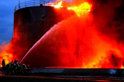 Los Bomberos trabajan en la extinción de un gran depósito de combustible atacado por un misil en las afueras de Lviv.