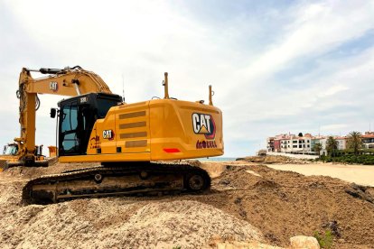 Una retroexcavadora mou sorres en una platja de Roda de Berà.