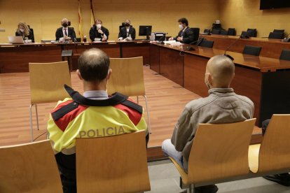 De espaldas y custodiado por los Mossos, el acusado de apuñalar al padre en Olot.