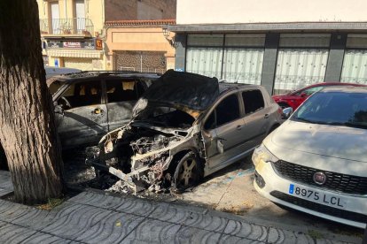 Imatge dels dos vehicles cremats durant la matinada de diumenge a dilluns al Portal Nou.