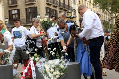 Familiars de les víctimes dels atemptats del 17-A dipositen els clavells blancs al memorial pla de l'Ós de la Rambla.