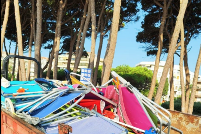 El camió de la Brigada Municipal carregat amb totes les cadires i para-sols retirats de la platja.