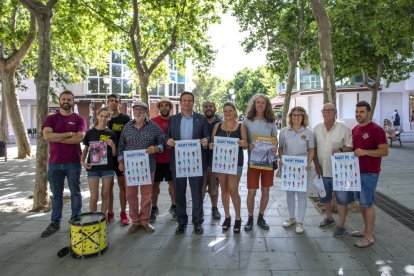 En el centro, el alcalde de Cambrils, Oliver Klein, con representantes de las entidades festivas mostrando el cartel de las fiestas, ayer, en la plaza Mossèn Joan Batalla.