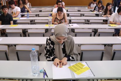 Alumnes enganxen l'etiqueta identificativa abans de començar l'examen de castellà de les PAU, al Campus Catalunya de la URV, a Tarragona.