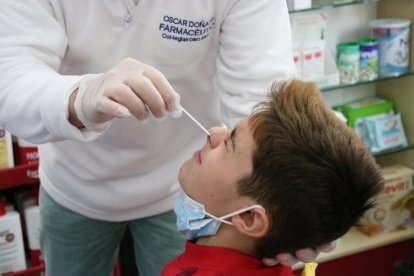 Un niño mientras un farmacéutico le realiza un test.