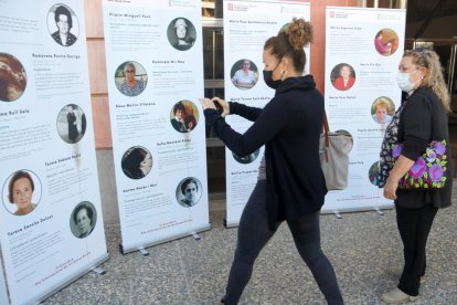 Plano medio donde se pueden ver dos mujeres observando la exposición 'Mujeres rurales. Mujeres de Lleida', en Tàrrega.