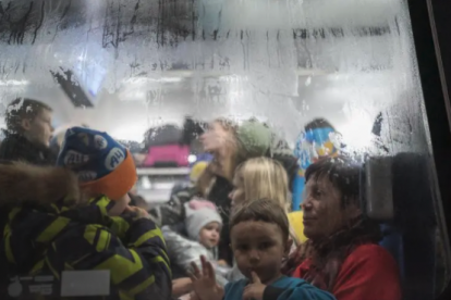 Un niño mira por la ventana de un vagón de tren en la estación de Lviv durante la invasión militar rusa de Ucrania.