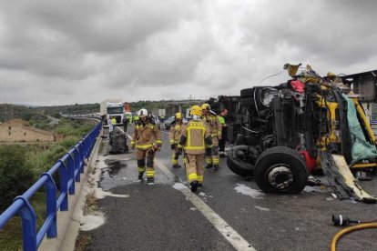 Un grup de bombers treballa al lloc de l'accident, on s'han vessat uns 200 litres de gasoil.