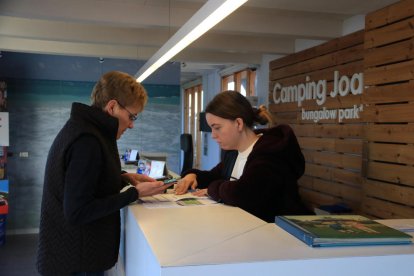 Una recepcionista del Camping Joan, en Cambrils, atèn a una cliente antes del puente de diciembre.