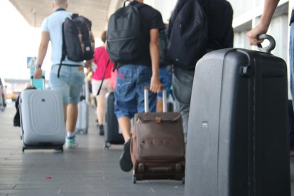 Turistas con maletas a la salida del aeropuerto del Prat.