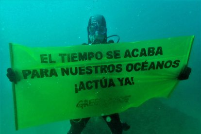 Un activista de Greenpeace despliega una pancarta submarina en la Mar Bella.