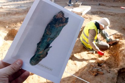 El fragment d'escultura de bronze que representa el déu Mercuri i un dels arqueòlegs excavant la necròpolis medieval.