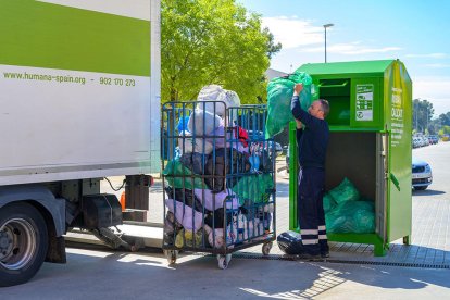 Un treballador recollint la roba utilitzada.