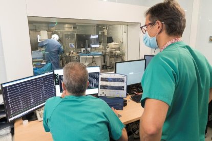 Dos professionals de l'Hospital de Bellvitge monitoritzen els resultats d'un pacient.