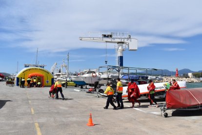 Els equips d'emergències atenent els afectats en el simulacre d'incendi en un catamarà al port de Cambrils.