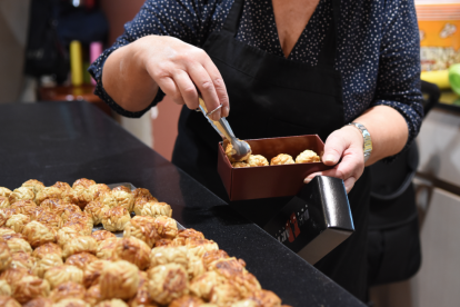 La dependienta de una pastelería prepara una caja de panellets.