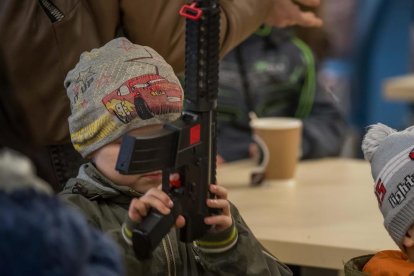 Un niño juega con una metralleta de juguete en una de las salas del estadio Arena Lviv reconvertidas en alojamiento para desplazados en Leópolis.