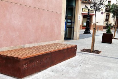 Accés condicionat al refugi antiaeri de la plaça de la Font de les Borges del Camp, amb un banc de ferro.