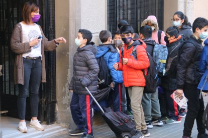 Imatge d'una professora prenent la temperatura als alumnes per accedir al centre.