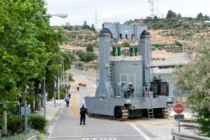 Operaris transprtant un contenidor de combustible nuclear gastat.