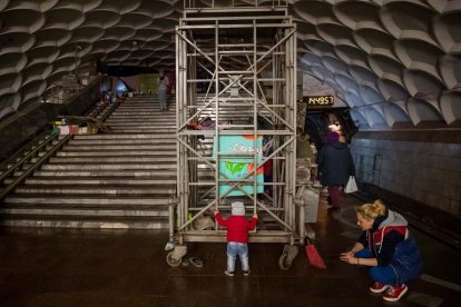 Una madre juega con su hija dentro de una estación de metro usada como refugio, en Jarkov.