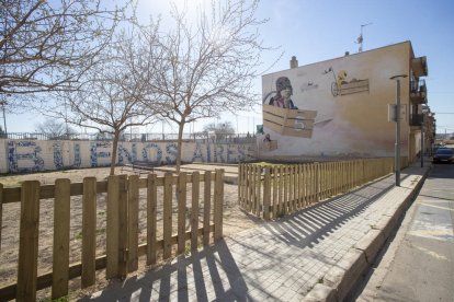 Una tanca de fusta protegeix el recinte de jocs dels infants.