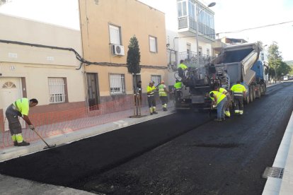 Operaris durant l'asfaltat del carrer de Roger de Llúria.