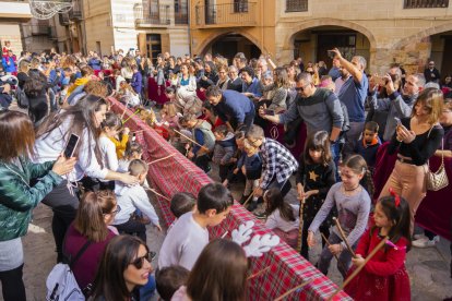 Els nens fent cagar el Tió més llarg del món a la plaça nova d'Alcover.