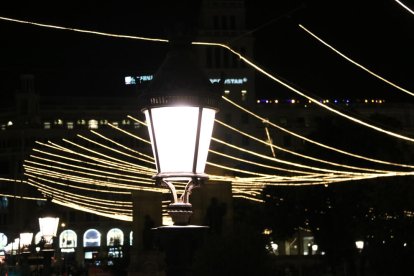 Un detall de l'enllumenat de Nadal de Barcelona al darrere d'un fanal.