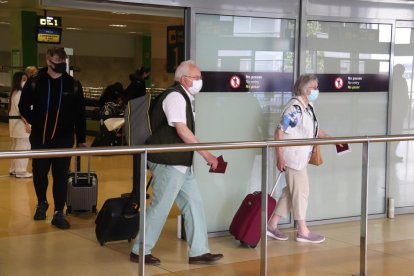 Plano abierto de varios pasajeros de Ryanair saliendo del aeropuerto de Girona.