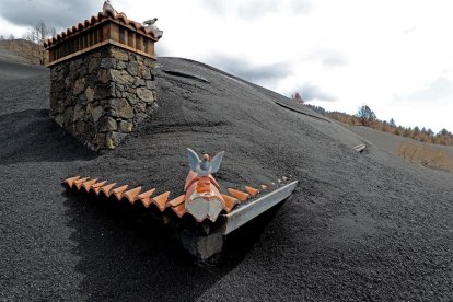 Una chimenea y un tejado sobresaliendo de la lava.