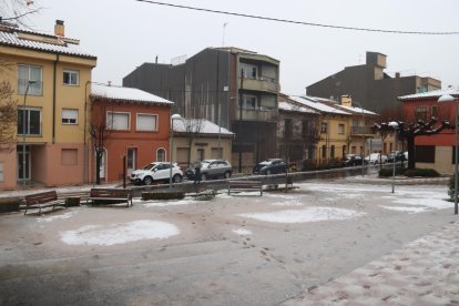 Varias casas de Sant Hilari Sacalm enharinadas y una plaza con la nieve medio fundida por la lluvia.