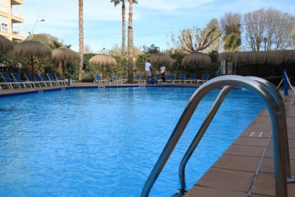 Dos operarios preparan la piscina del Hotel Sol Cambrils justo antes del inicio de Semana Santa.