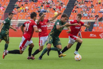 Pedro León perseguit per tres jugadors del Nàstic en el partit de la primera volta al Nou Estadi.