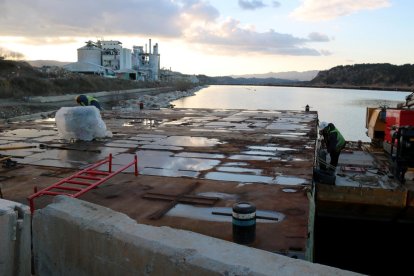 Operaris en una de les barcasses que es faran servir en el procés de restitució de la zona descontaminada del pantà.