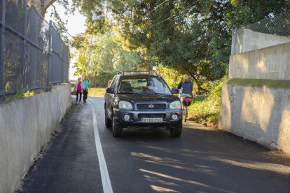 Imatge d'un vianant, un vehicle i una bicicleta circulant pel reformat camí de la Pedra Estela.